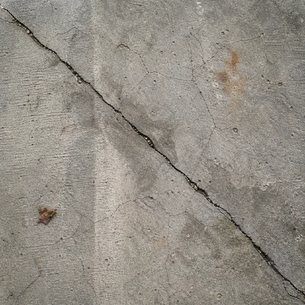 Old cracked concrete slab with worn paint on it before preparation