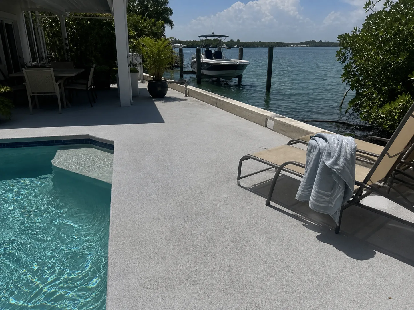 Terraza de piscina en caucho frente al agua en Key Biscayne, llega hasta el muro de contenci&oacute;n