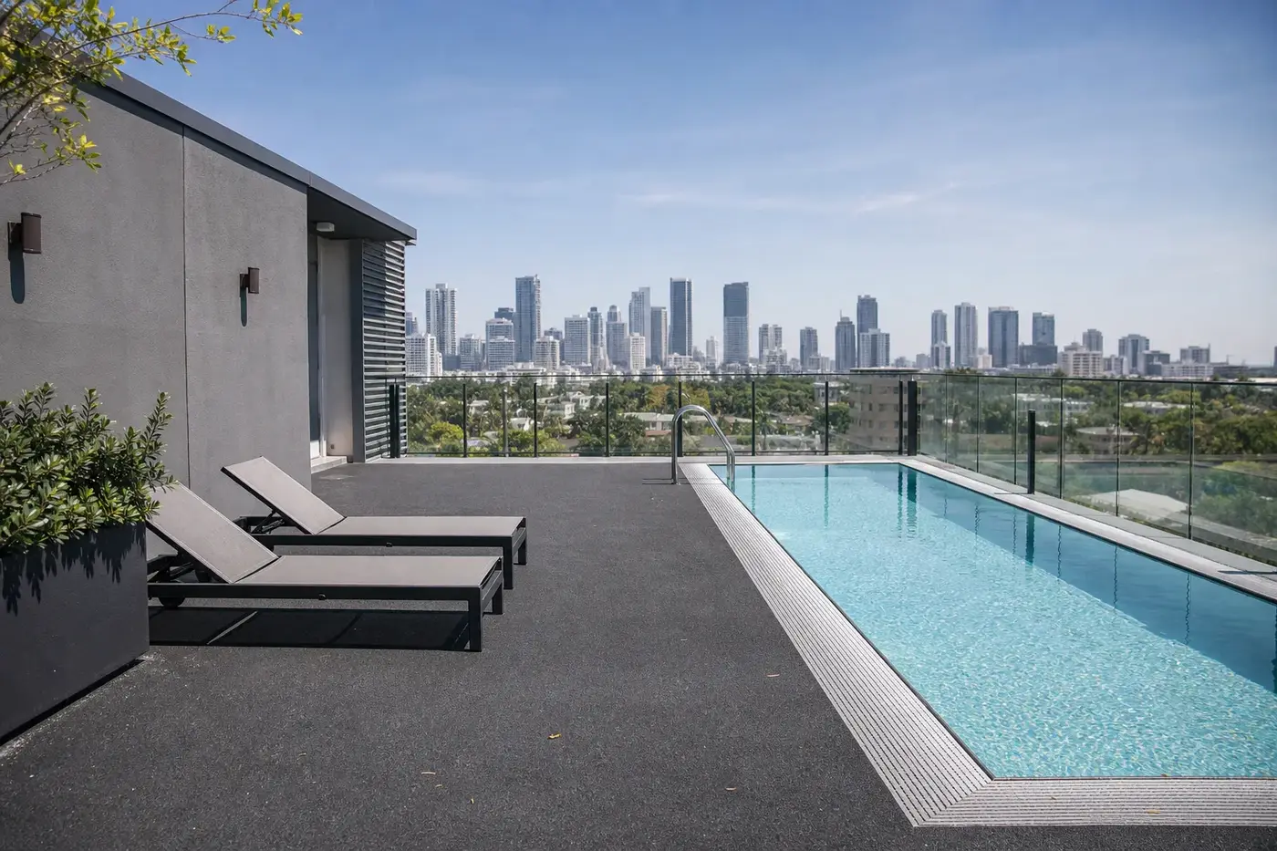 Rooftop rubber pool deck on a Miami condo tower with the skyline behind