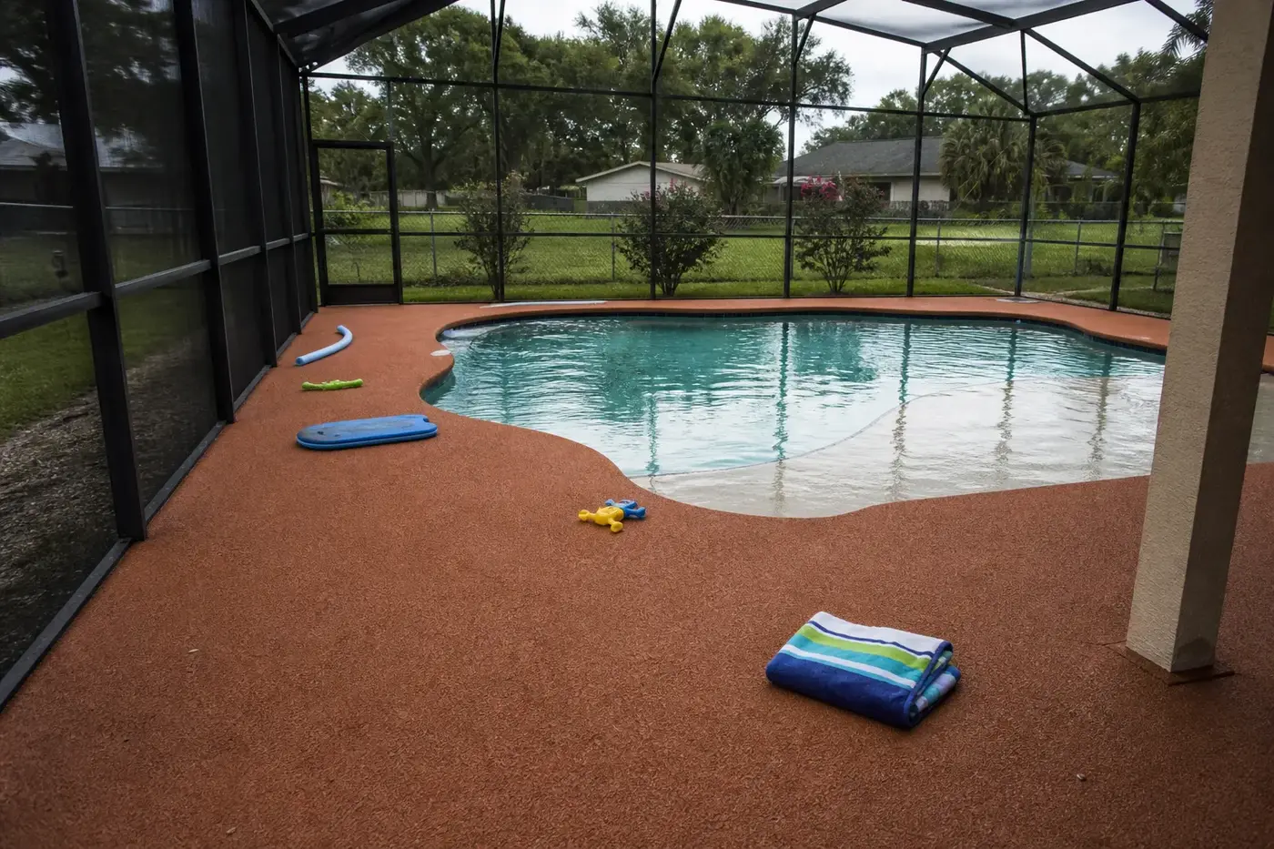 Screen enclosed rubber pool deck at a Miramar family home