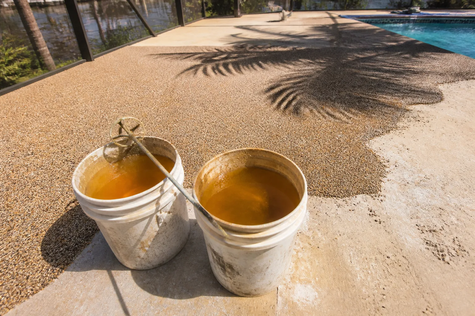 Two pails of polyurethane binder on a half poured rubber deck